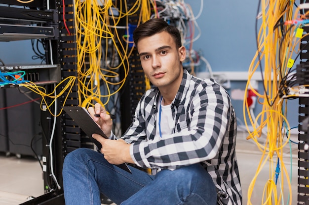 Apuesto ingeniero escribiendo en portapapeles