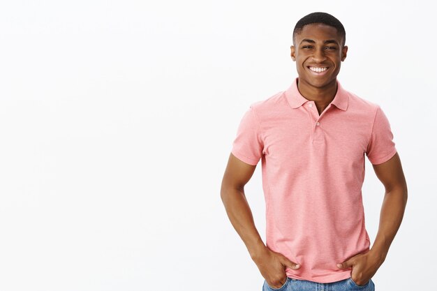 Apuesto joven afroamericano con camiseta polo rosa