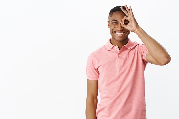 Apuesto joven afroamericano con camiseta polo rosa