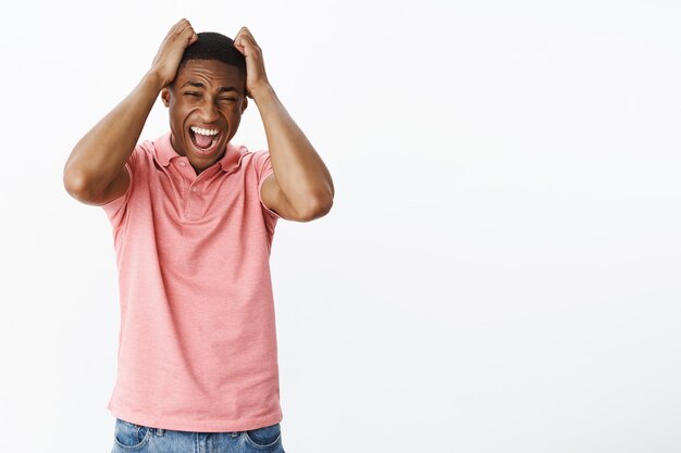 Apuesto joven afroamericano con camiseta polo rosa