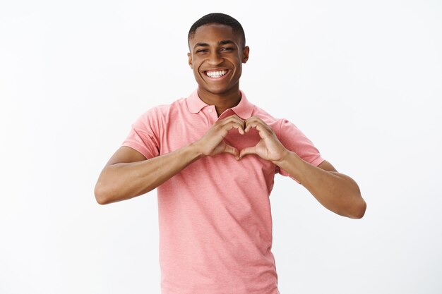 Apuesto joven afroamericano con camiseta polo rosa