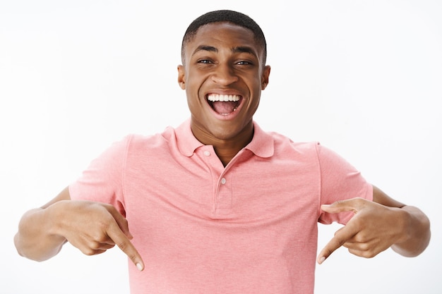 Apuesto joven afroamericano con camiseta polo rosa