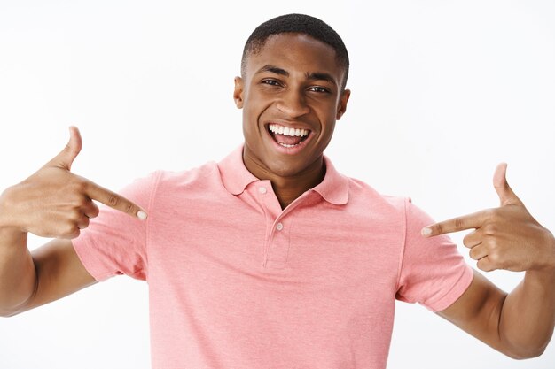 Apuesto joven afroamericano con camiseta polo rosa