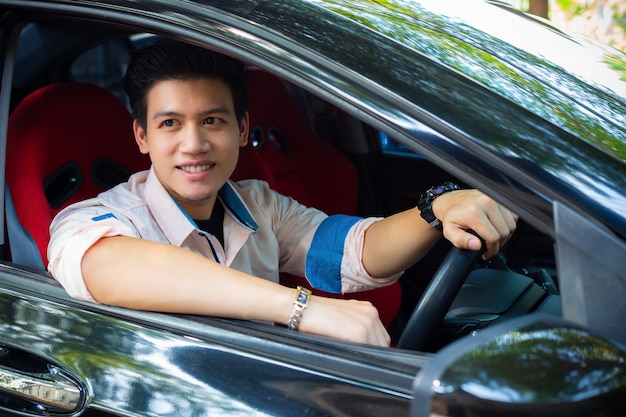 Apuesto joven en coche negro