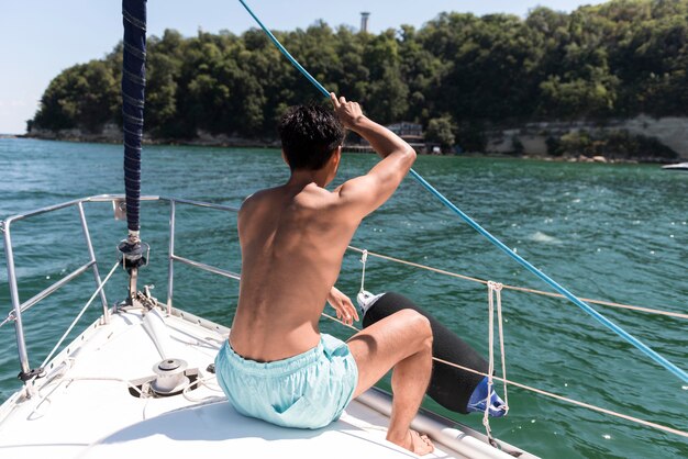 Apuesto joven disfrutando de tiempo en barco