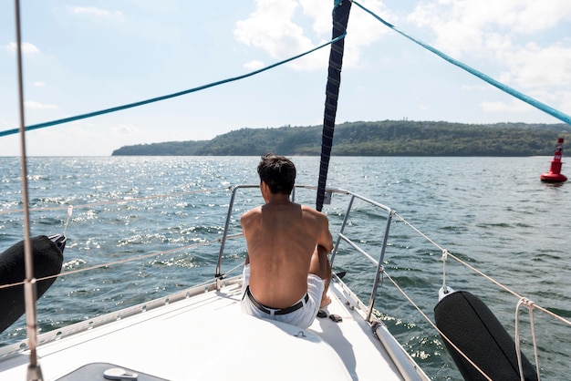 Apuesto joven disfrutando de tiempo en barco