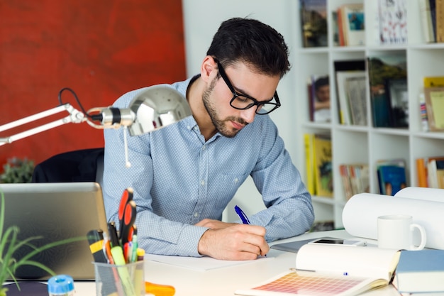 Apuesto joven empresario trabajando en la oficina.