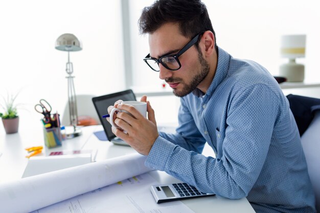 Apuesto joven empresario trabajando en la oficina.