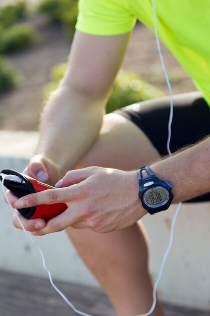 Apuesto joven escuchar música después de correr.