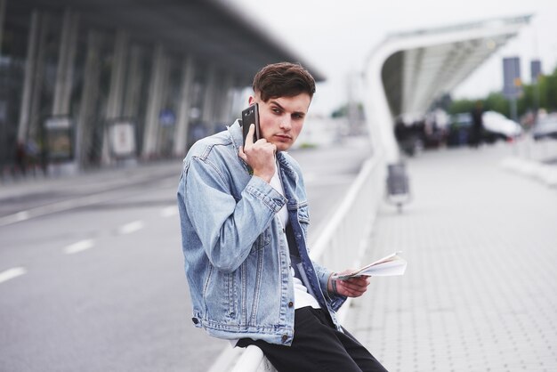 Un apuesto joven hablando por teléfono cerca de la oficina.