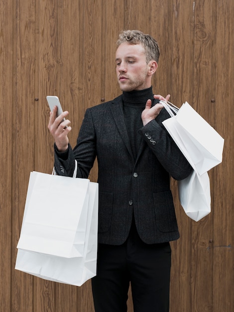 Apuesto joven mirando smartphone