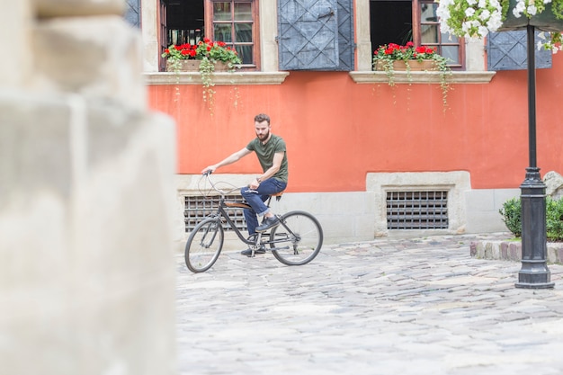 Foto gratuita apuesto joven montando en bicicleta