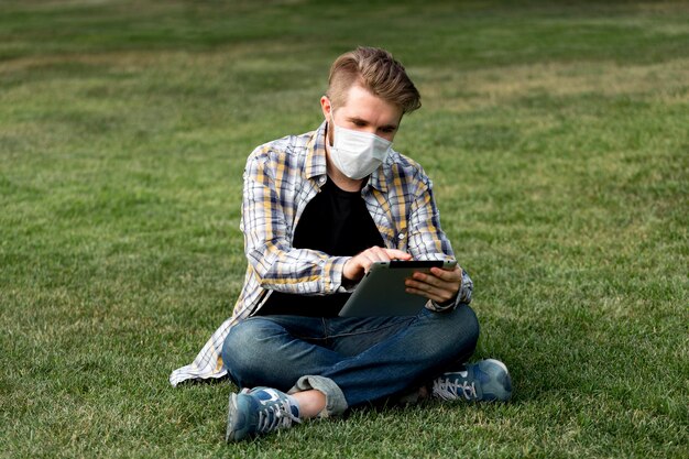 Apuesto joven tableta de navegación al aire libre