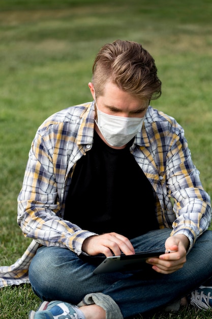 Apuesto joven tableta de navegación al aire libre