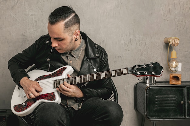 Foto gratuita apuesto rockero tocando la guitarra eléctrica