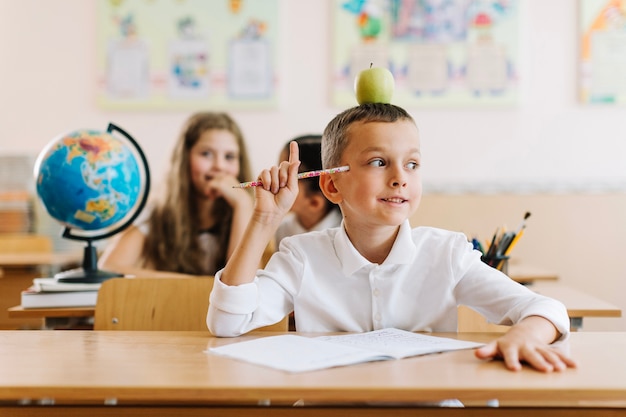 Apuntando a niño sentado en la clase