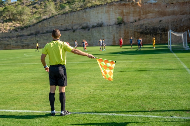 Árbitro asistente en un partido de fútbol viendo el partido | Foto Premium