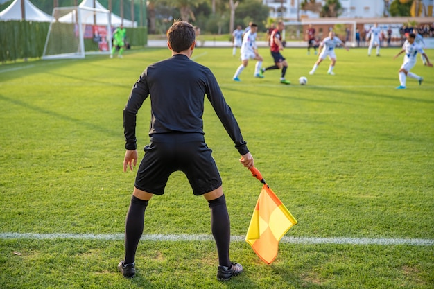 Árbitro asistente en un partido de fútbol viendo el partido | Foto Premium