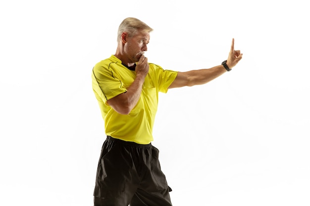 El árbitro da instrucciones con gestos a los jugadores de fútbol o fútbol mientras juega aislado sobre fondo blanco de estudio.