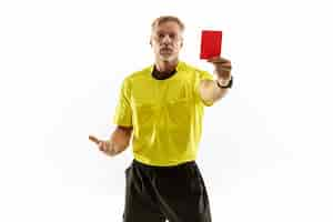 Foto gratuita Árbitro que muestra una tarjeta roja a un jugador de fútbol o fútbol disgustado mientras juega aislado sobre fondo blanco de estudio.