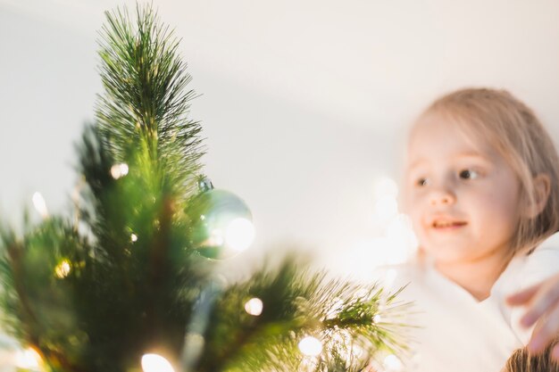 árbol de navidad iluminado y niña