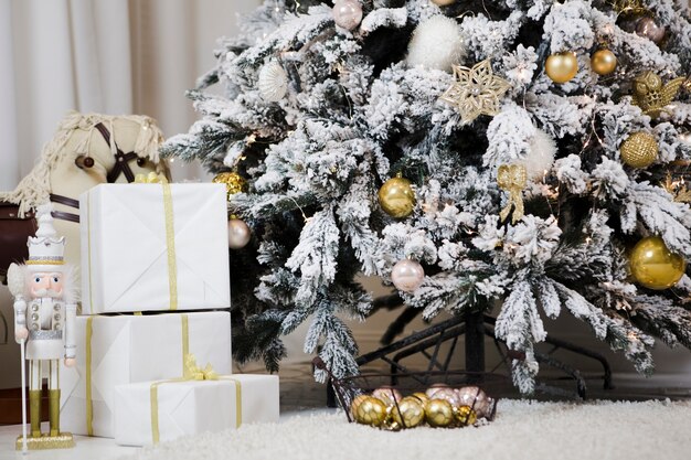 árbol de navidad con nieve y regalos