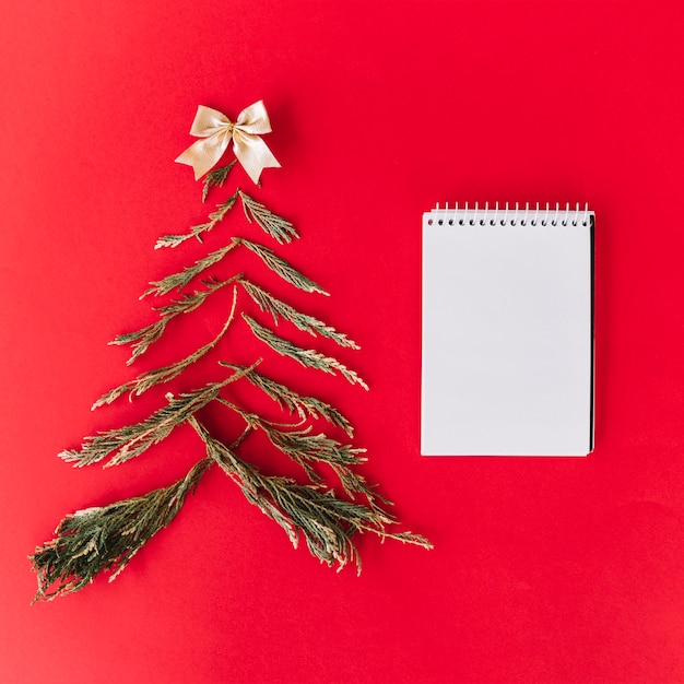 Foto gratuita Árbol de navidad de ramas de abeto con bloc de notas