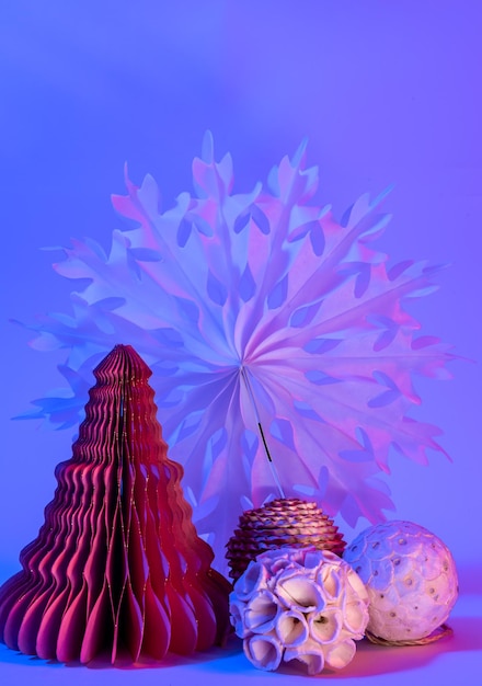 Foto gratuita Árboles de navidad de papel decorativo sobre fondo azul con luz de neón de moda