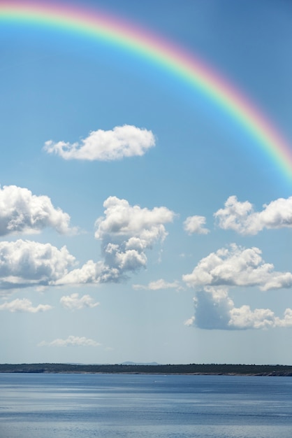 Arco iris en el cielo con paisaje natural.