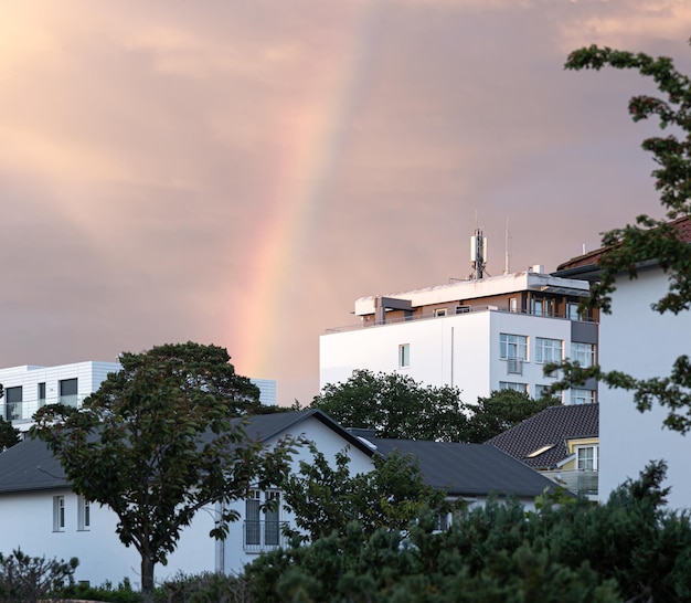 Arco iris en el cielo en una zona residencial entre casas