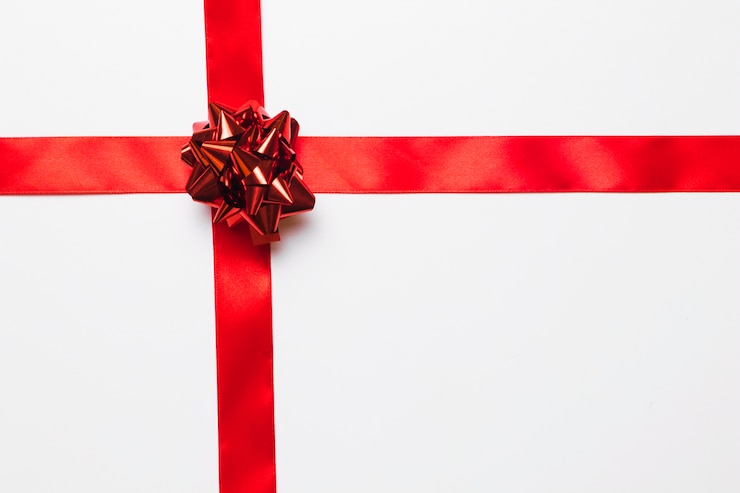 Foto gratuito arco de regalo rojo brillante con lazo de seda.