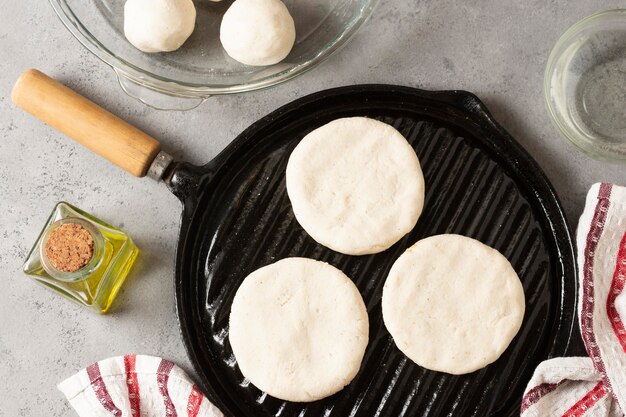 Arepas crudas vista superior en sartén