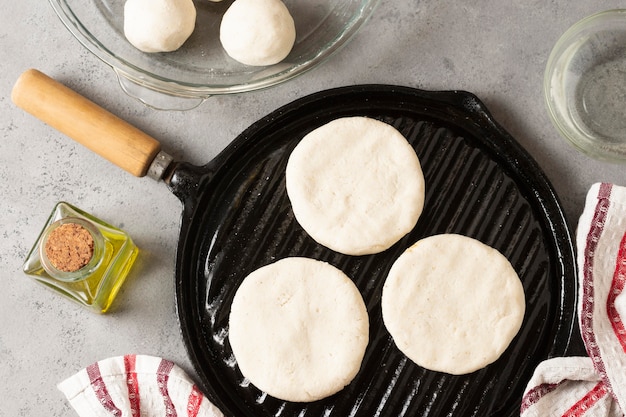 Arepas crudas vista superior en sartén