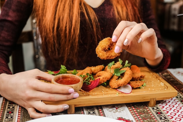 Foto gratuita aros de calamar frito con salsa de rábano, perejil, sésamo y ají dulce