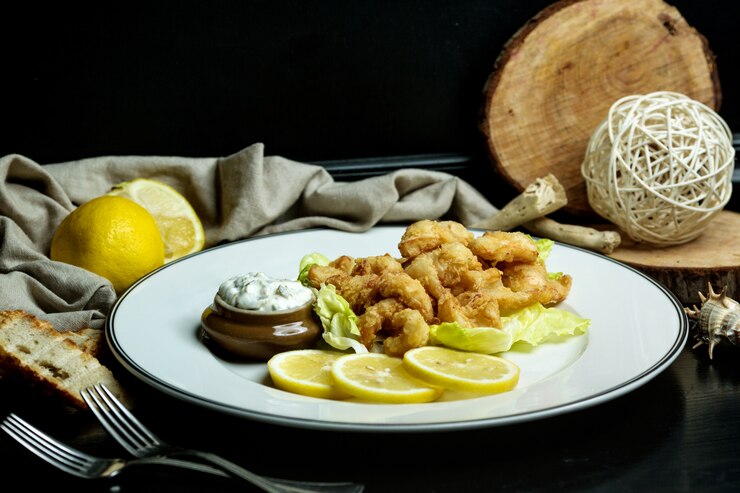 Foto gratuito aros de calamares servidos con limón y mayonesa