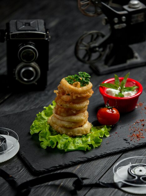 Aros de cebolla rebozados con salsa y tomate