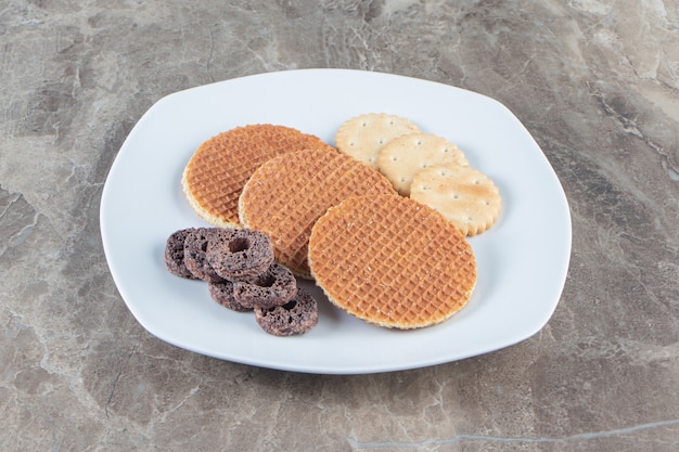 Foto gratuita aros de galleta, galleta y maíz en placa sobre mármol.