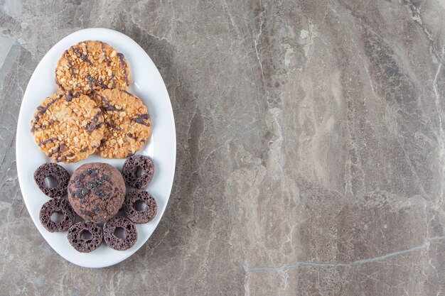 Aros de maíz y galletas caseras en un plato de mármol.