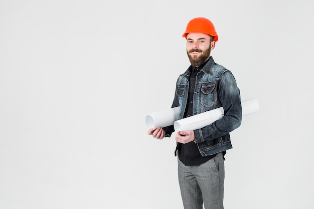 Arquitecto que sostiene el modelo blanco enrollado contra el fondo blanco