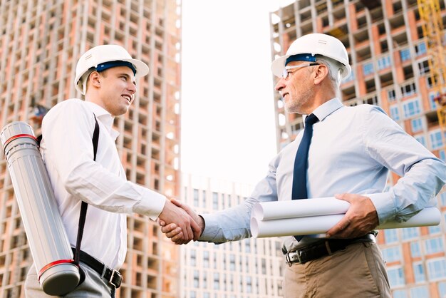 Arquitectos de ángulo bajo dándose la mano