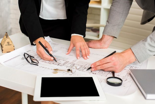 Arquitectos estudiando un plan con maqueta