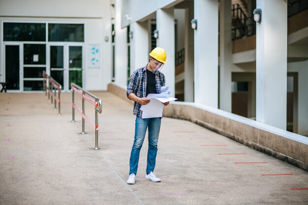 Los arquitectos sostienen el plan de construcción y verifican el trabajo.