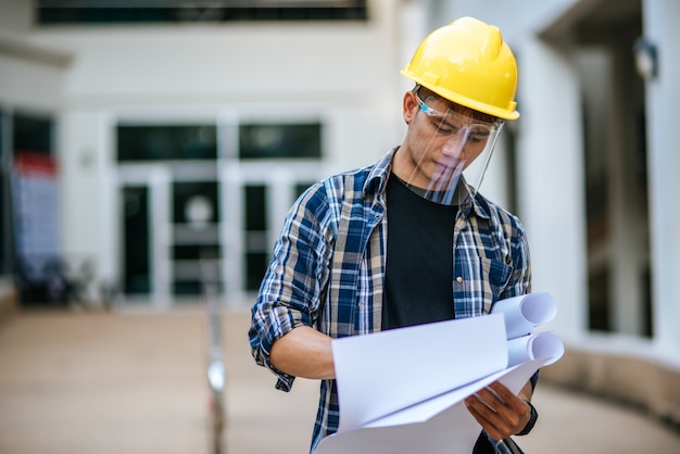 Los arquitectos sostienen el plan de construcción y verifican el trabajo.