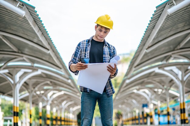 Los arquitectos sostienen el plan de construcción y verifican el trabajo.