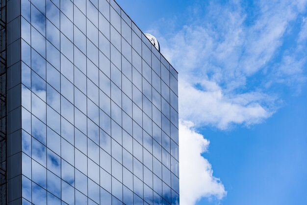 Arquitectura de edificio de cristal moderno con cielo azul y nubes