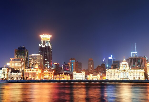 Arquitectura histórica de Shanghai en la noche iluminada por luces sobre el río Huangpu