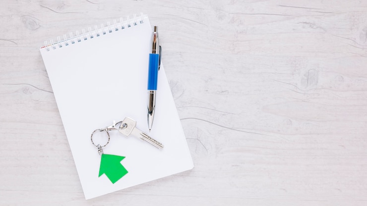 Photo Gratis arranged notepad with pen and key
