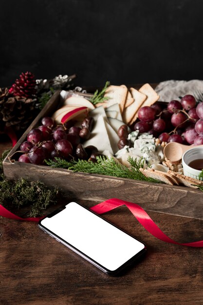 Arreglo de alto ángulo de comida navideña con smartphone vacío