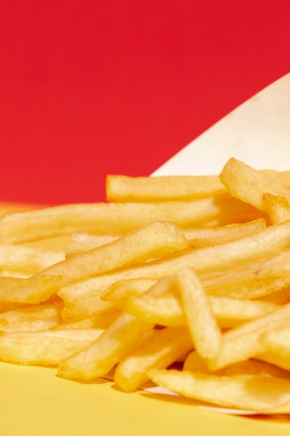 Foto gratuita arreglo de alto ángulo con papas fritas y fondo rojo.