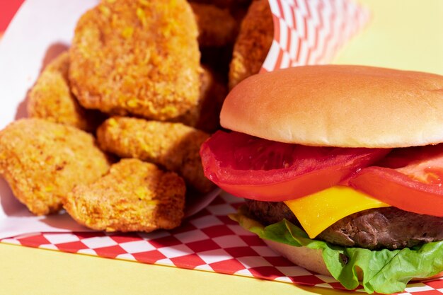 Foto gratuita arreglo de alto ángulo con pepitas y hamburguesa con queso